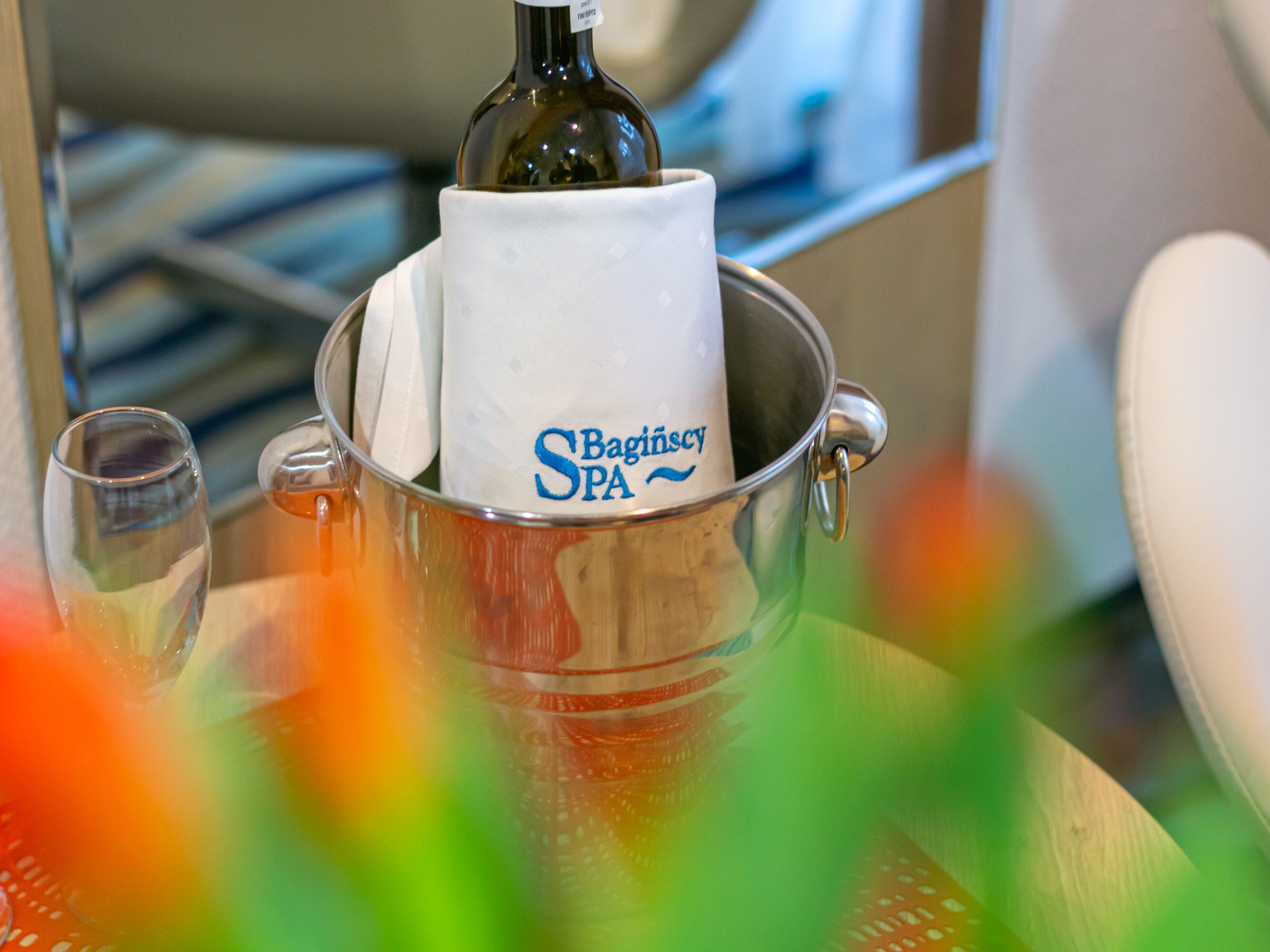 A spa setting with a white container labeled "Baginsky SPA" and a bottle, likely containing a beverage, on a reflective surface.