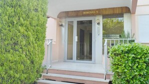 A building entrance with a glass door and a sign reading "MIMOSAS 1".