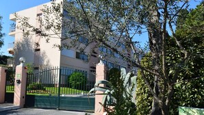 A gated entrance to a building with a sign indicating '65 Les Jardins'.