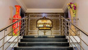 Un magnifique escalier en marbre, avec des marches en marbre et une niche décorative au centre.
