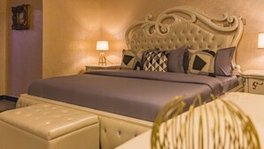 Une chambre à coucher bien aménagée, avec un grand lit, une table de chevet dotée d’une lampe et un élément décoratif mural.