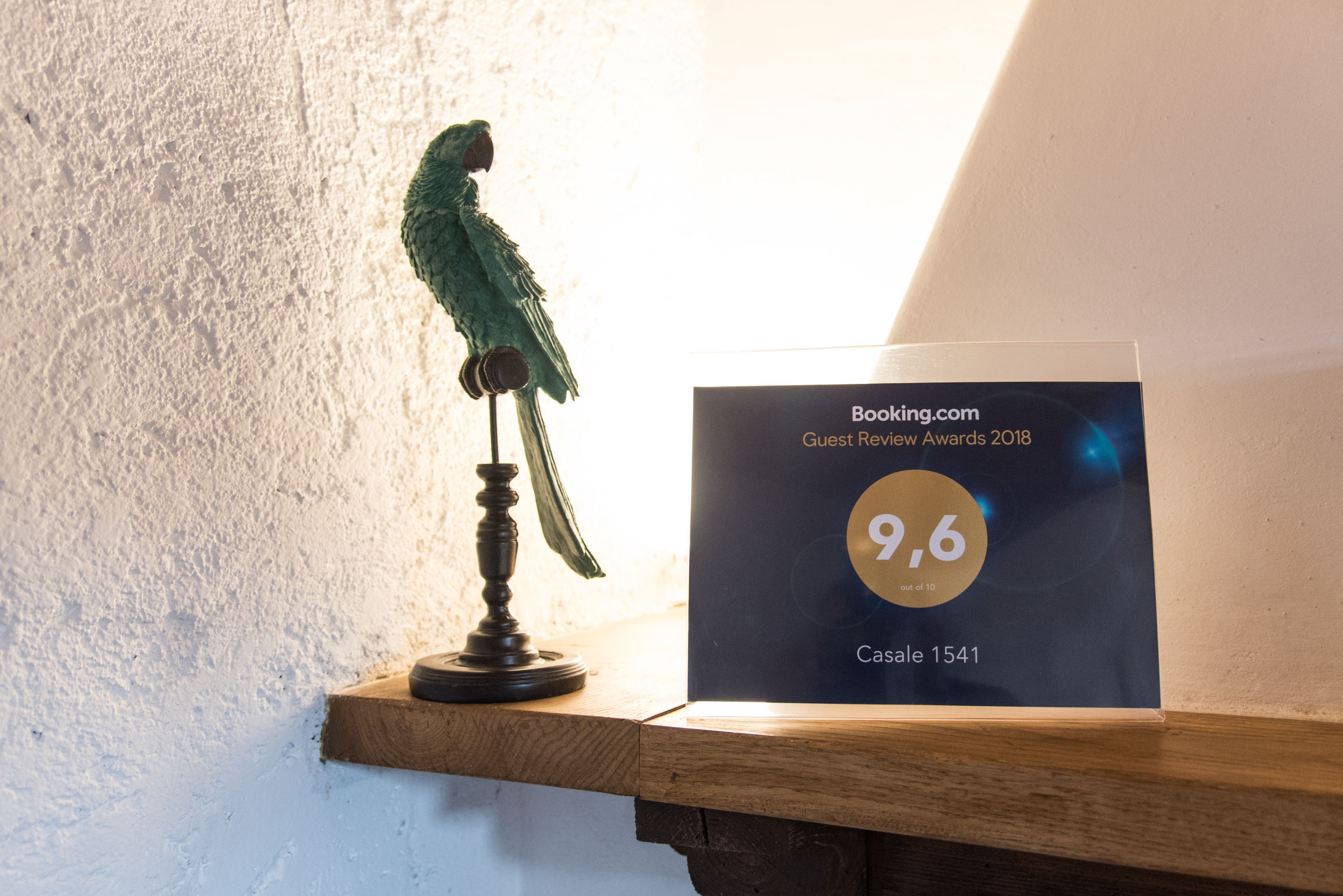 A wooden shelf with a framed guest review award from Booking.com for a 9.6 rating.