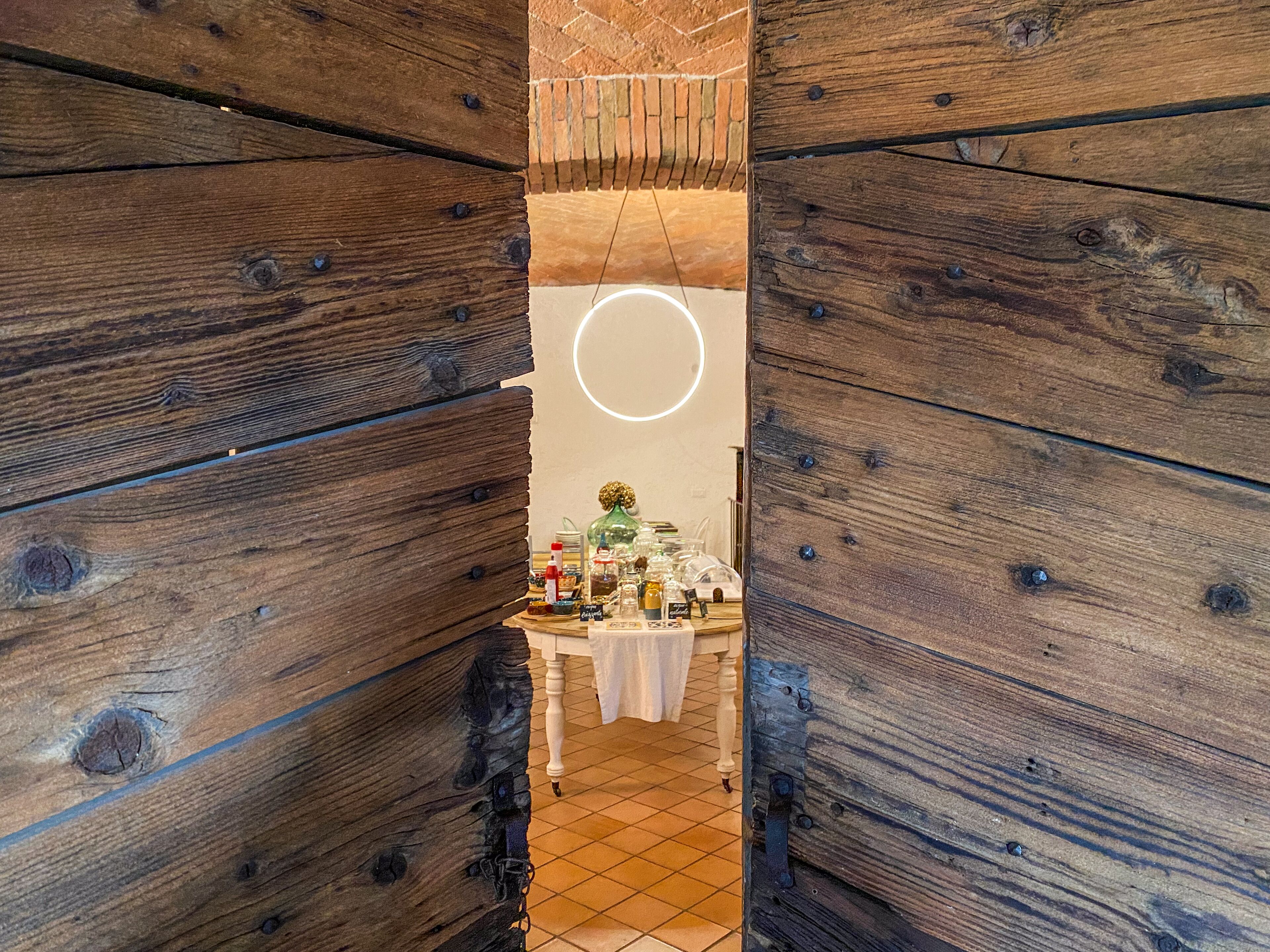 A narrow hallway with wooden walls and a table with various items in the center.