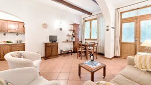 Amplia sala de estar con mesa de comedor, sofás y televisor.