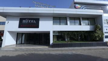 A hotel with a sign reading "HOTEL RESTAURANT" and a visible entrance.