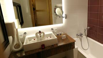A bathroom with a sink, mirror, and shower.
