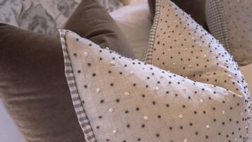 A bed with a patterned headboard, a pillow with a polka dot design, and a checkered pillow.