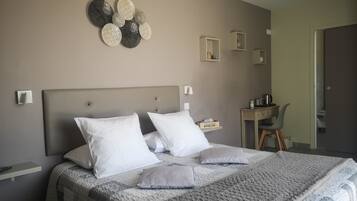 Una camera da letto ordinata con un letto grande, comodini, una scrivania e una mensola a parete.