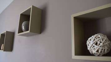 Three minimalist wall-mounted shelves with geometric shapes containing decorative items.