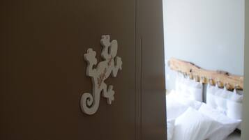 A room with a bed, pillows, and a decorative wall piece.