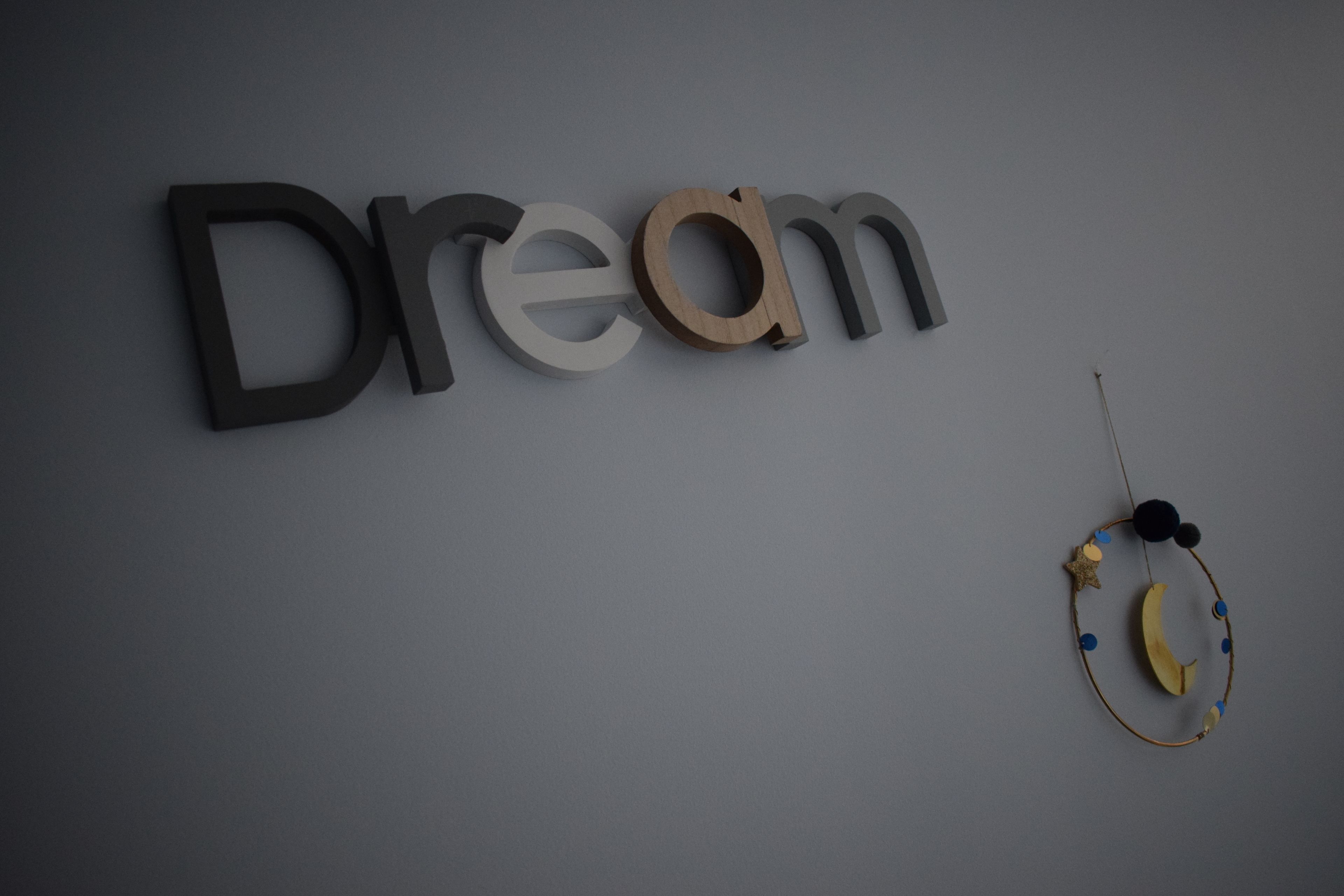 Het woord 'Dream' in driedimensionale letters op een effen muur.