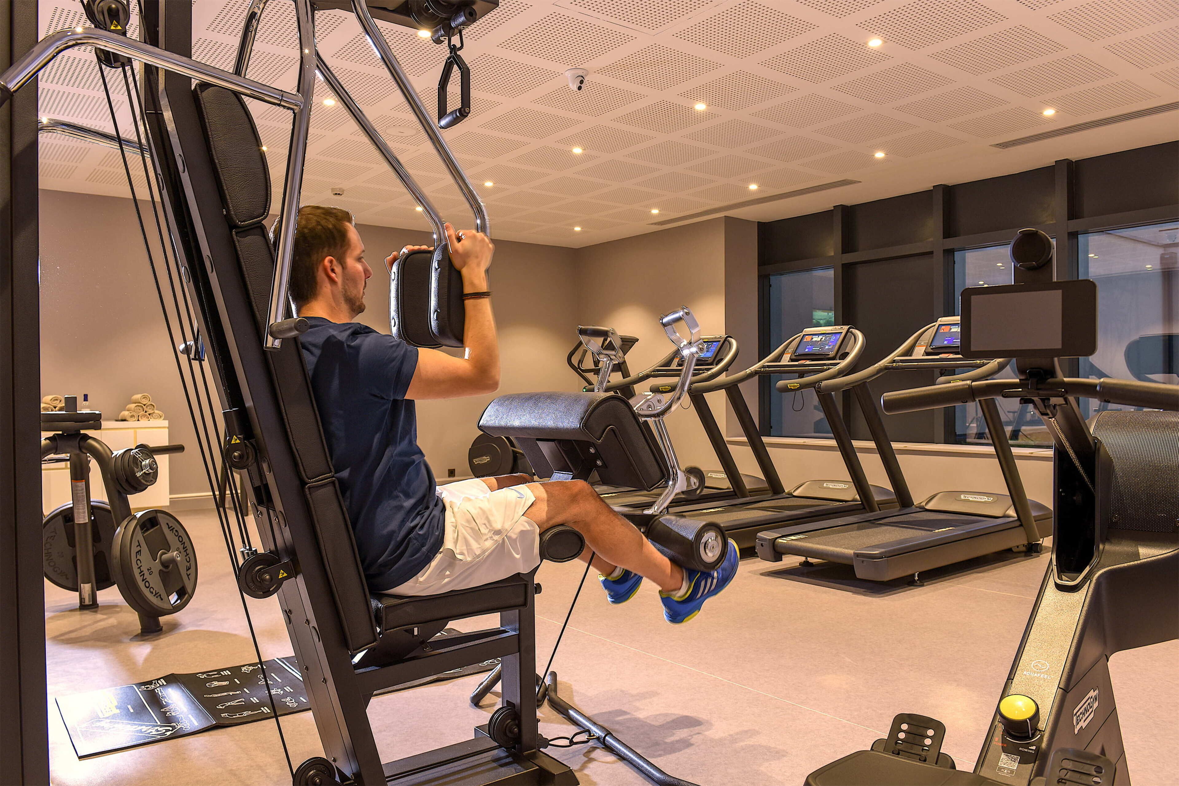 A gym with exercise equipment, treadmills, and weight machines.