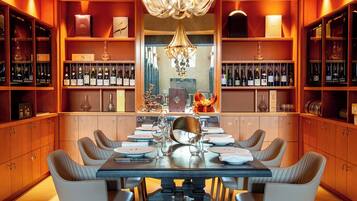 A dining area with a large table, chairs, and wine racks.