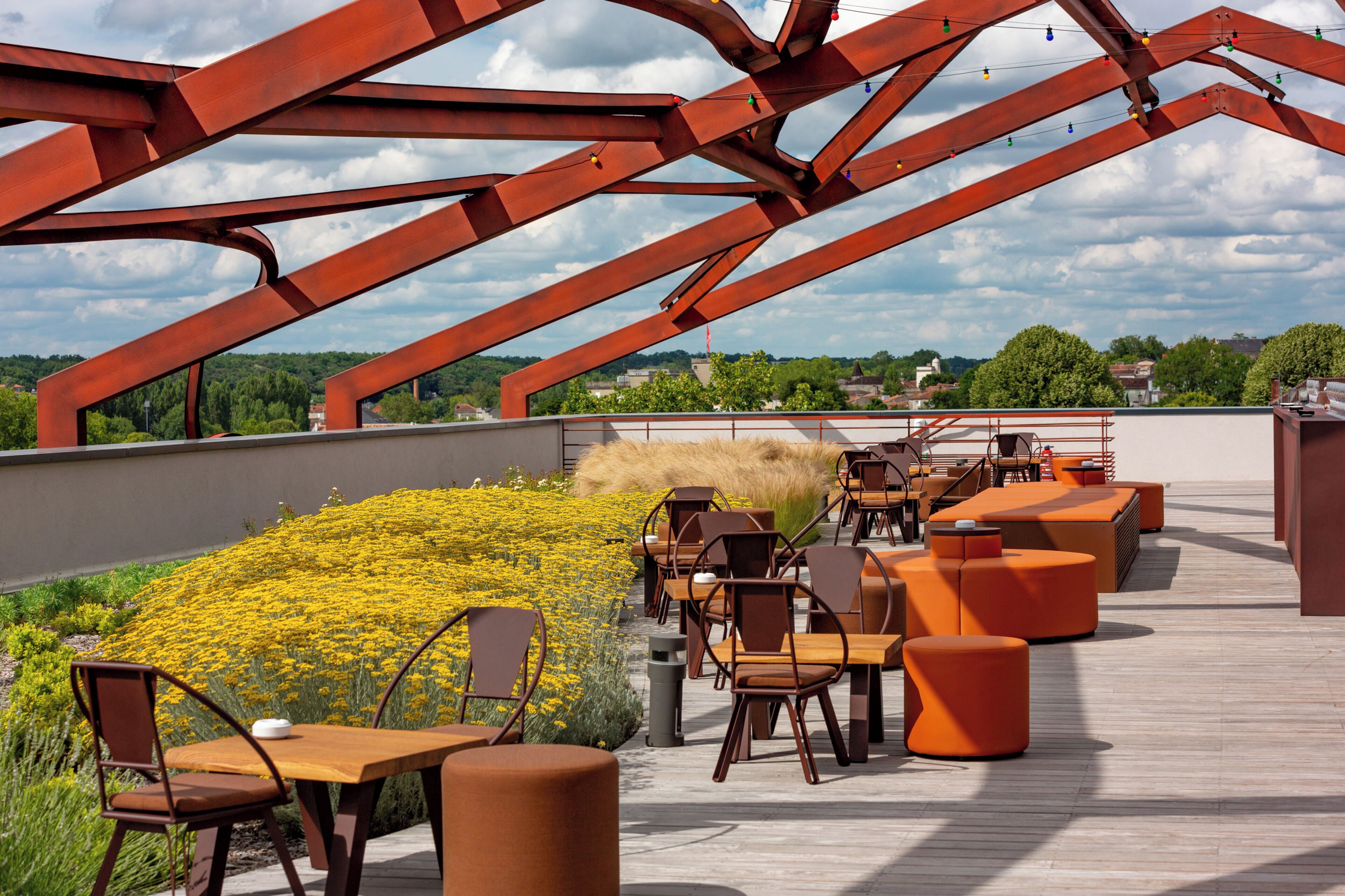 Terraza en la azotea con mobiliario exterior, vistas del paisaje y una estructura metálica roja distintiva.