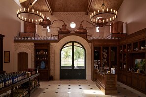 A spacious room with a large arched doorway, wooden cabinets, and a chandelier.