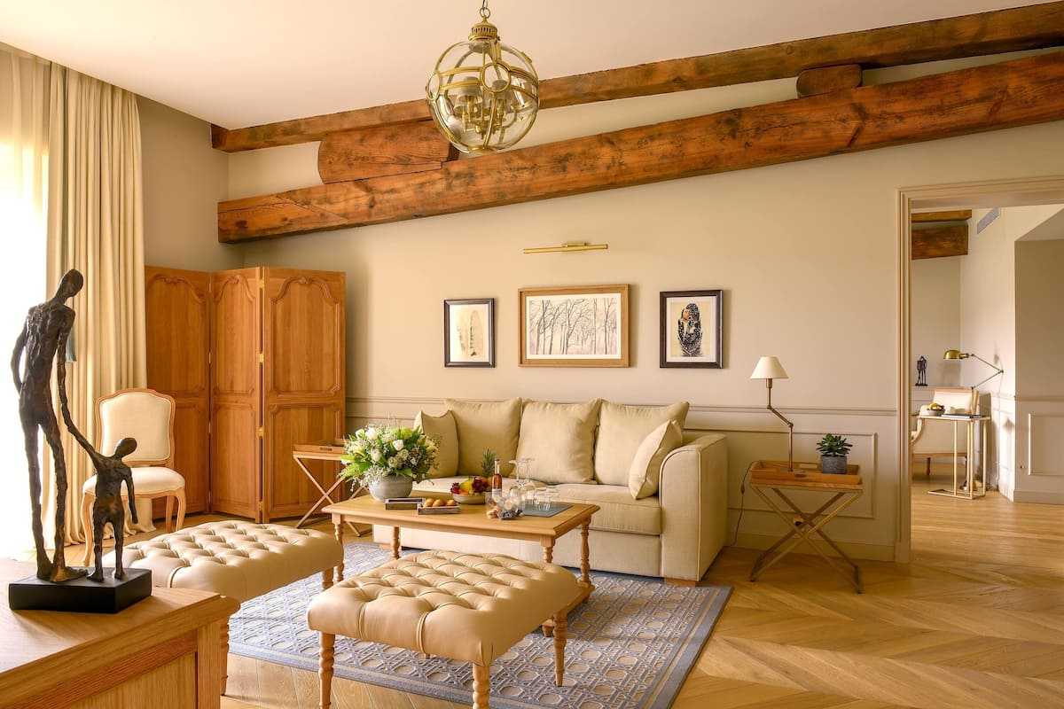 A living room with a wooden ceiling, a sofa, a coffee table, and a decorative sculpture.