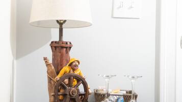 Et træbord med en lampe, et indrammet billede og vinglas.
