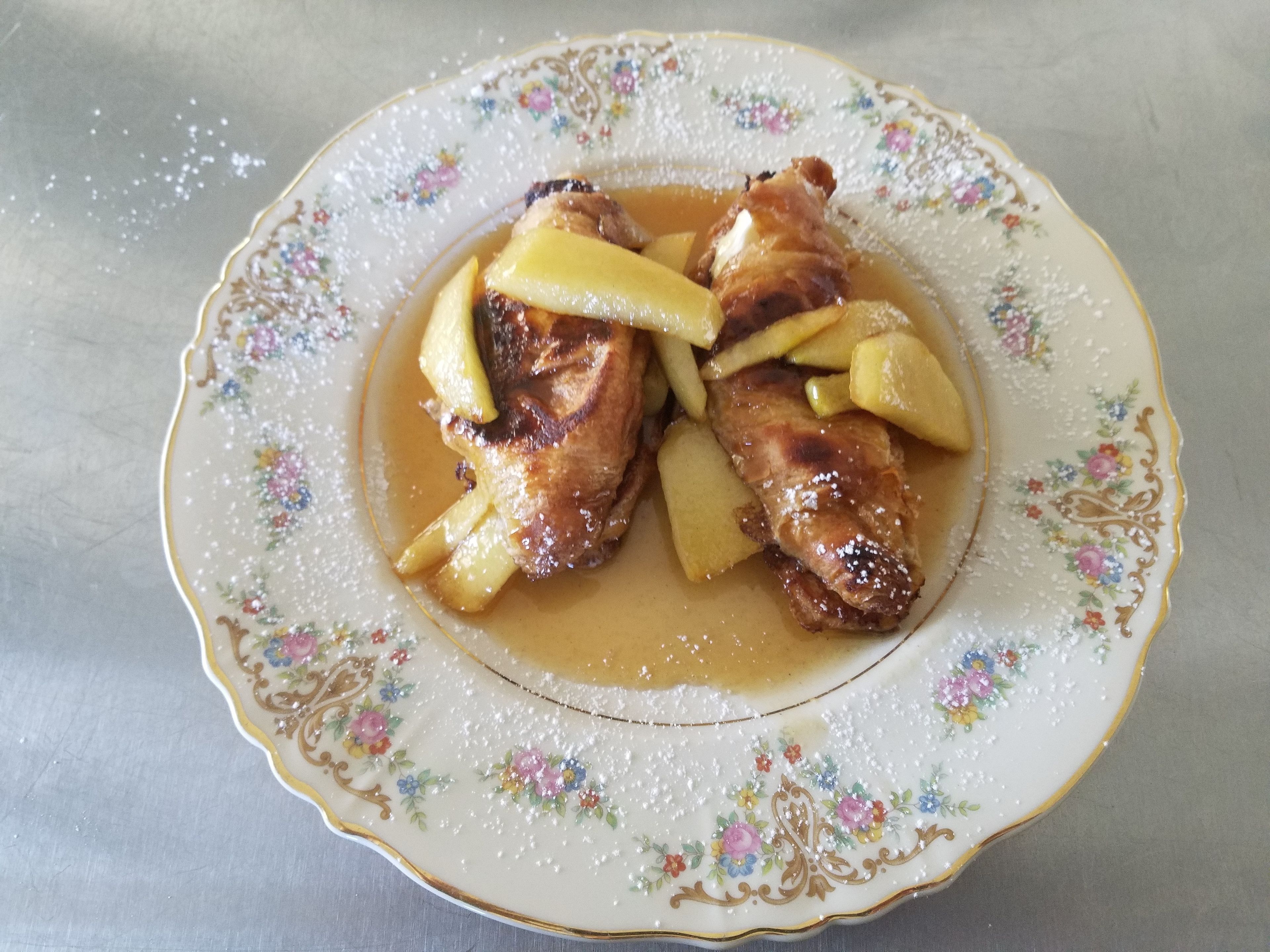 Un plat amb un dibuix floral i un tros de carn amb patates.