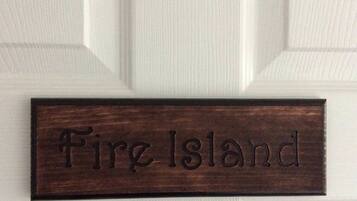 A wooden nameplate with the text "Fire Island" mounted on a white door.