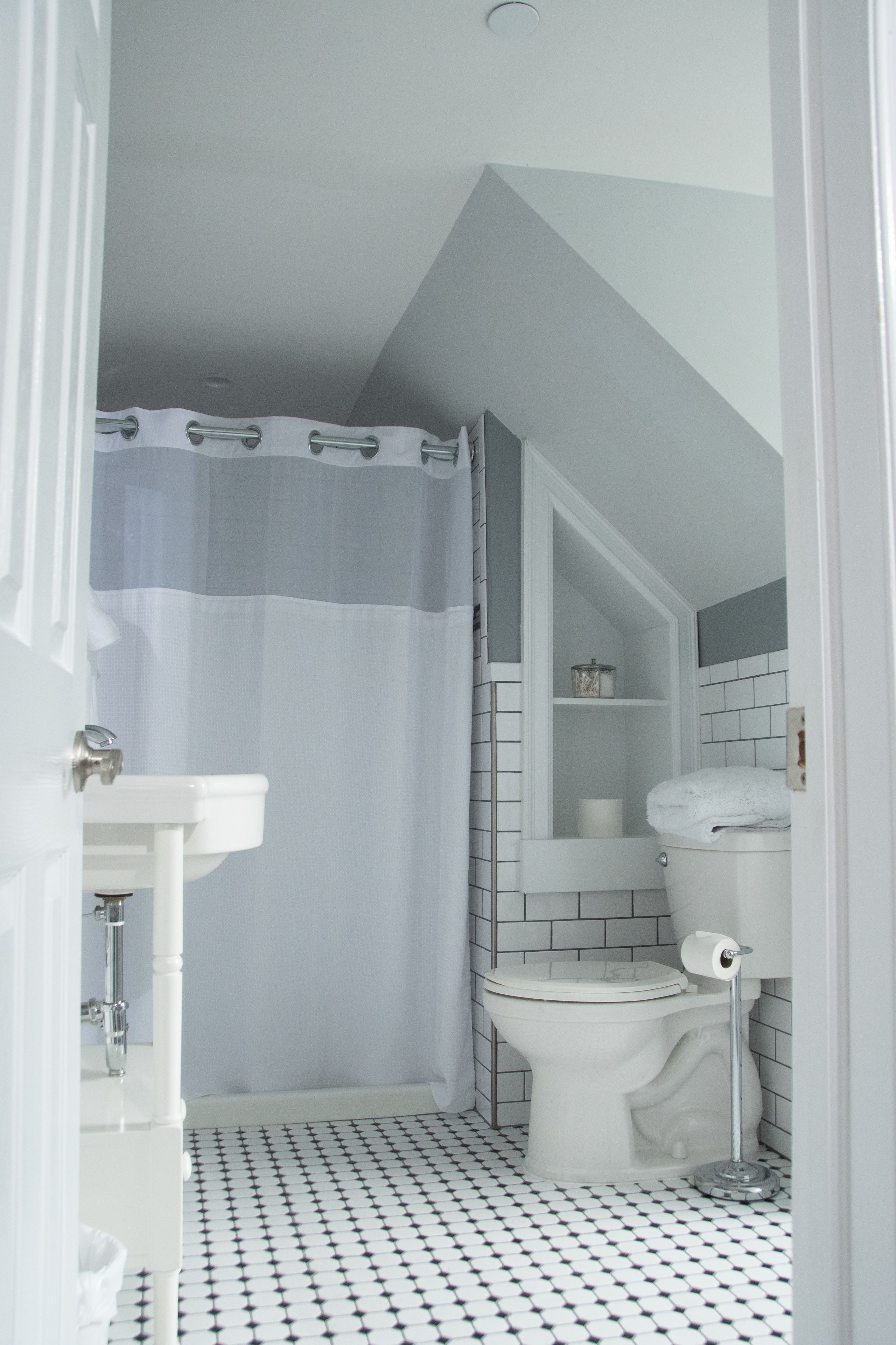 A bathroom with a white toilet, a sink, and a shower curtain.