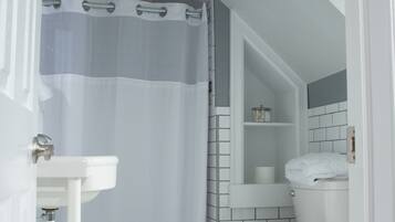 A bathroom with a white toilet, a sink, and a shower curtain.