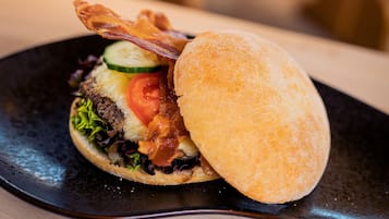 Un sándwich de tocino, tomate y lechuga servido en un plato negro.