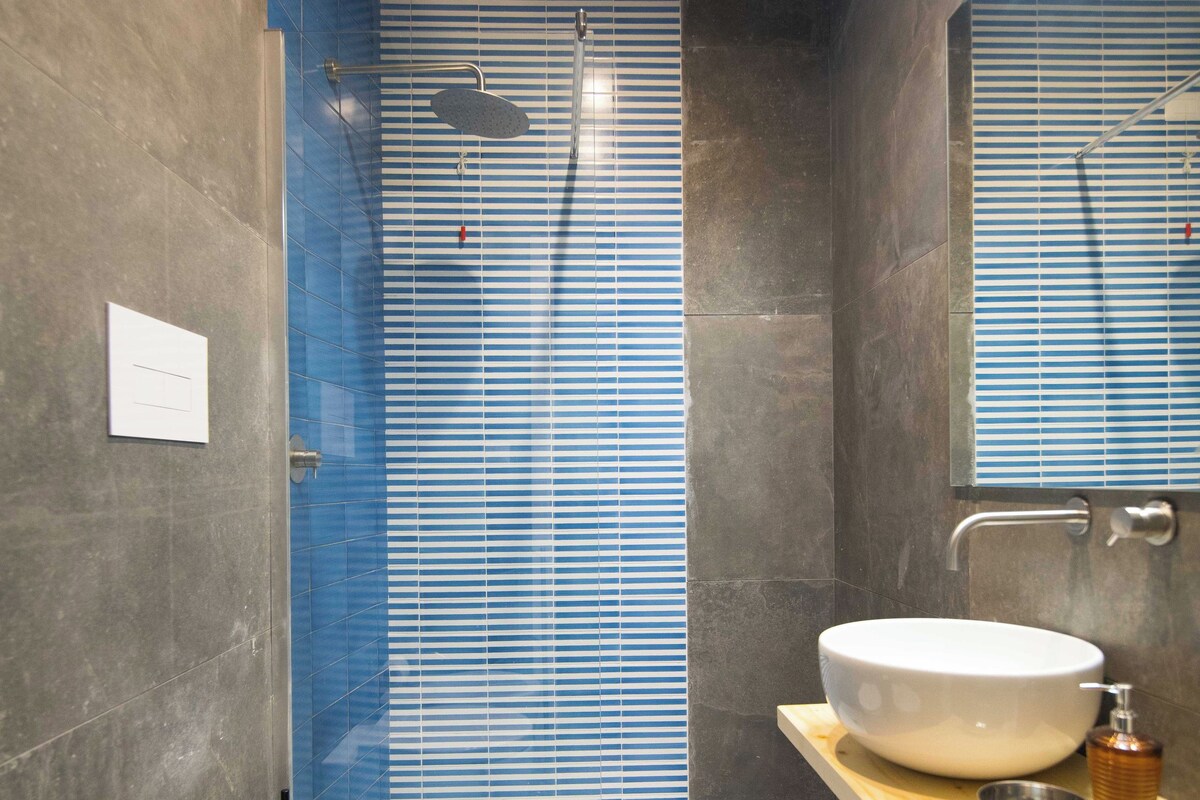 A modern bathroom with a toilet, bidet, and sink.
