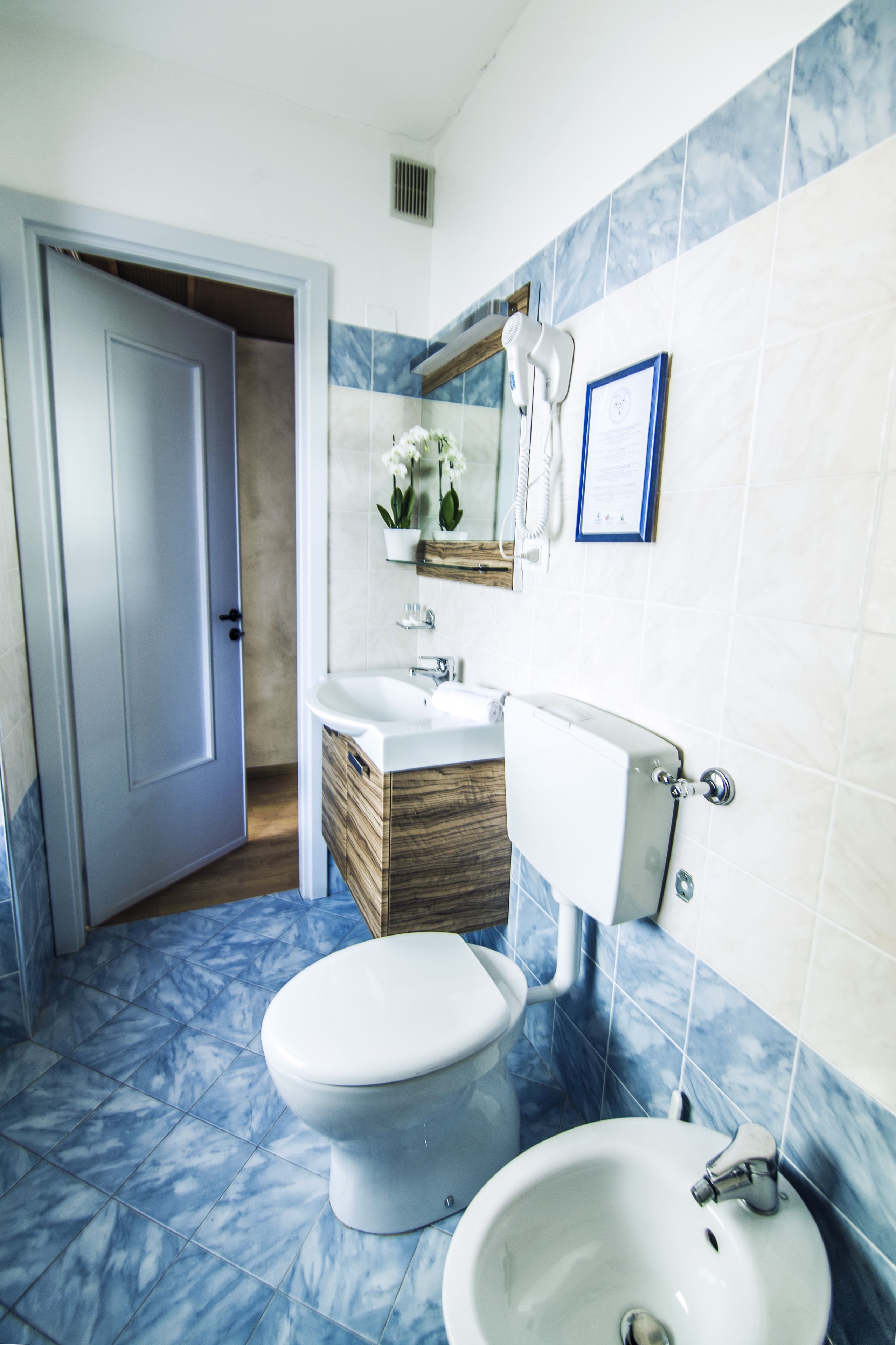 A bathroom with a toilet, bidet, and sink.