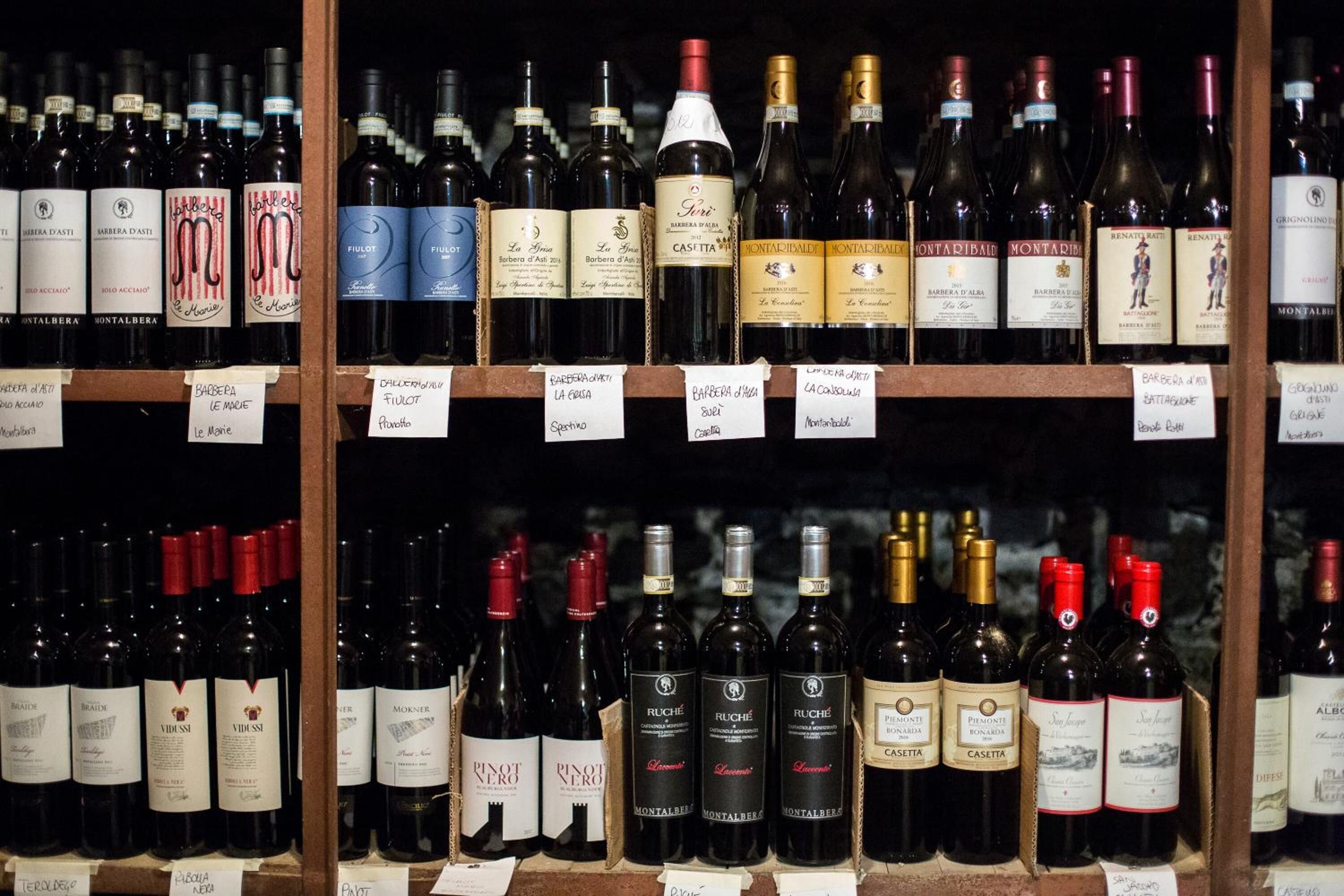 A wine rack with various bottles of wine, each labeled with the name and type of wine.