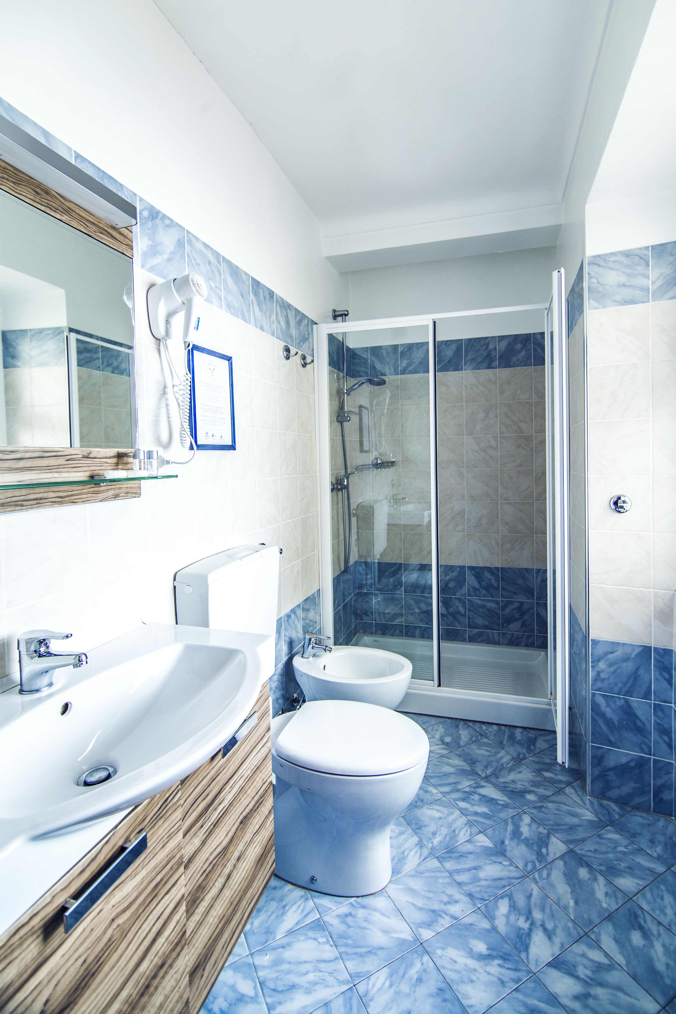 Une salle de bain avec douche, toilettes et lavabo.