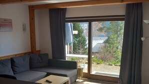 Un salon avec un canapé, une table basse et une vue sur l’extérieur.