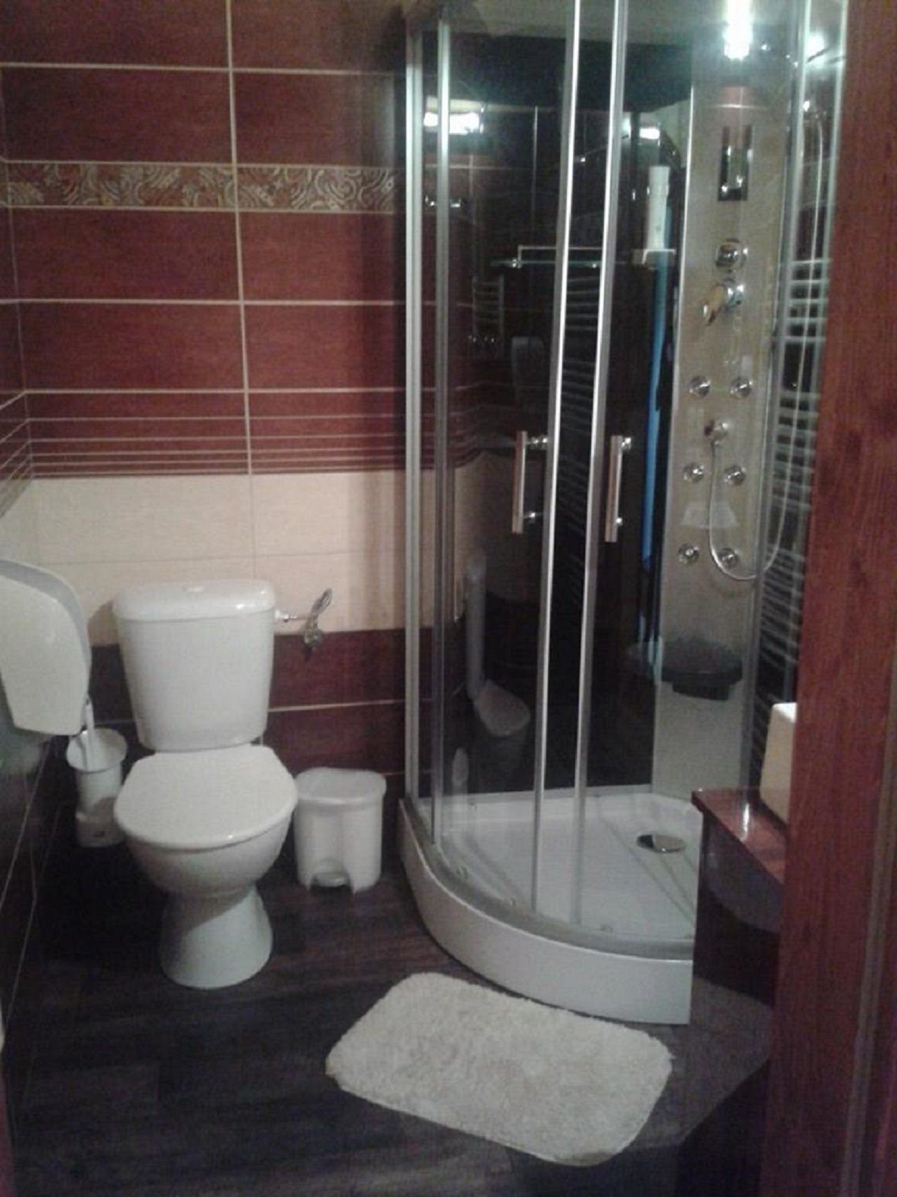 Une salle de bain équipée de toilettes, d’un bidet et d’une cabine de douche en verre.