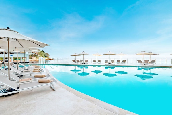 Alberca techada, 2 albercas al aire libre y sombrillas en la alberca