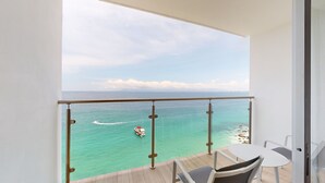 A balcony with a view of turquoise waters and a boat.