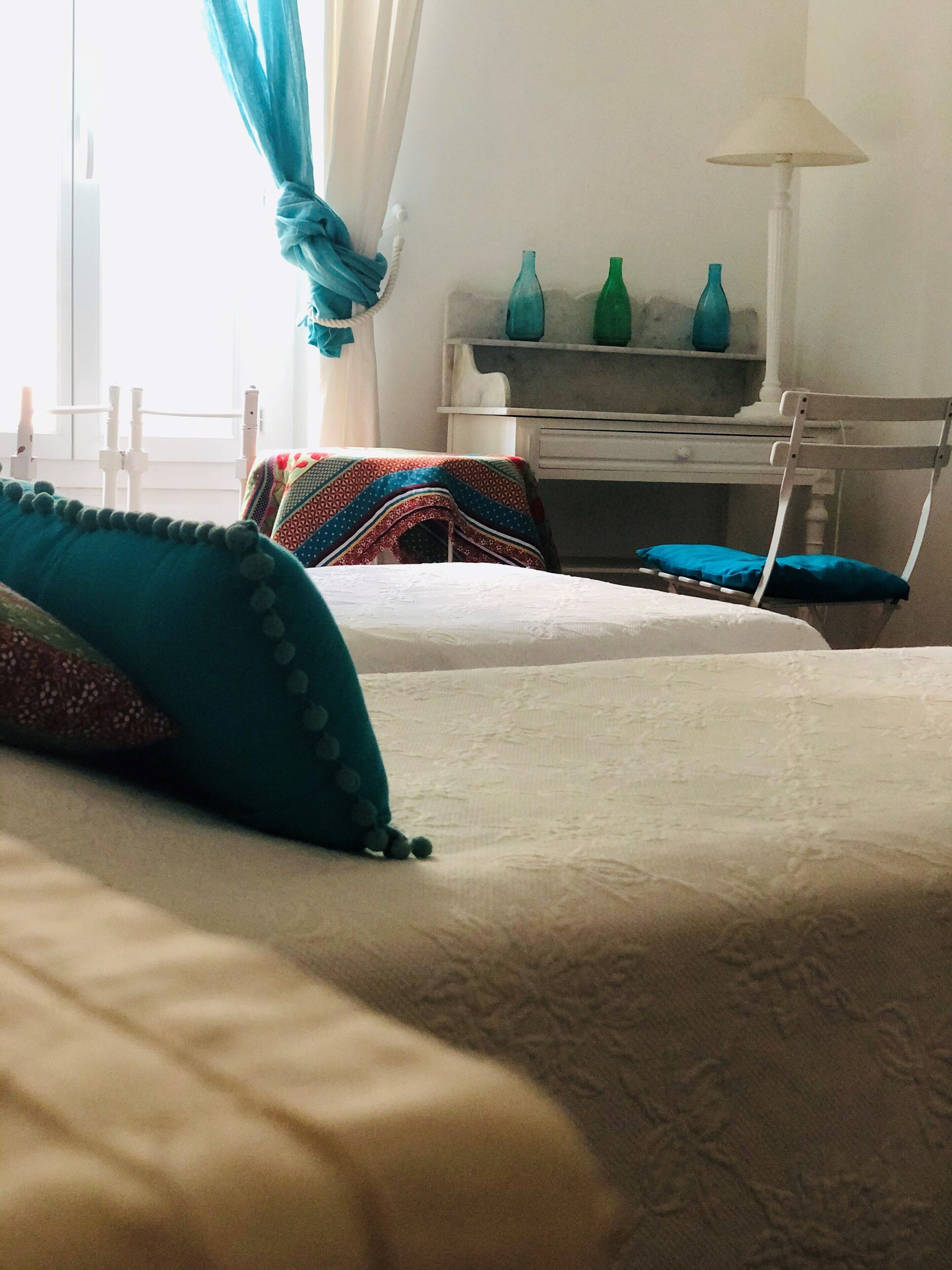 Une chambre à coucher avec un lit, une chaise, un bureau et une lampe.