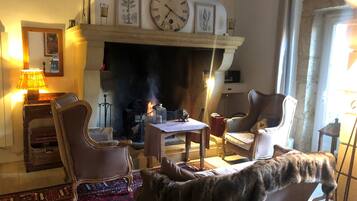 Una sala de estar acogedora con chimenea, un reloj y un gato.