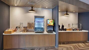 A modern kitchen area with wooden cabinets, a built-in coffee machine, and a refrigerator.