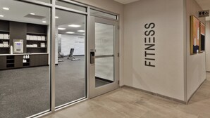 A fitness center with glass doors, a reception area, and a sign indicating the location. - Fairfield Inn & Suites by Marriott Birmingham Colonnade (Birmingham)