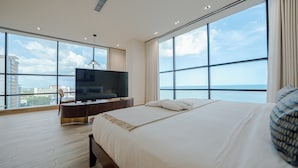 A modern hotel room with a large bed, a flat-screen TV, and a city view through floor-to-ceiling windows. - Mauad Hotel Boutique (Santo Domingo)