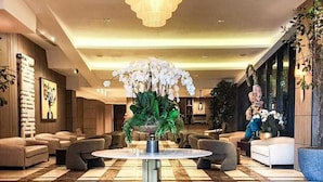 A spacious lobby with a large chandelier, plush seating, and a checkered marble floor. - Mauad Hotel Boutique (Santo Domingo)