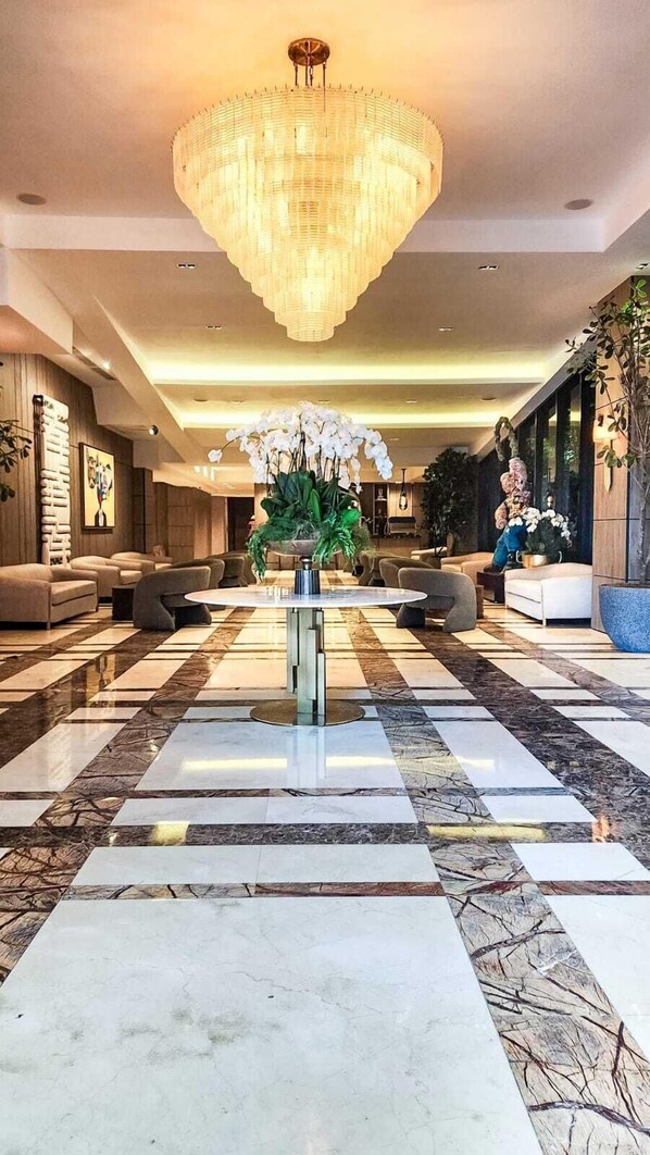 A spacious lobby with a large chandelier, plush seating, and a checkered marble floor. - Mauad Hotel Boutique & Spa, a member of Radisson Individuals (Santo Domingo)