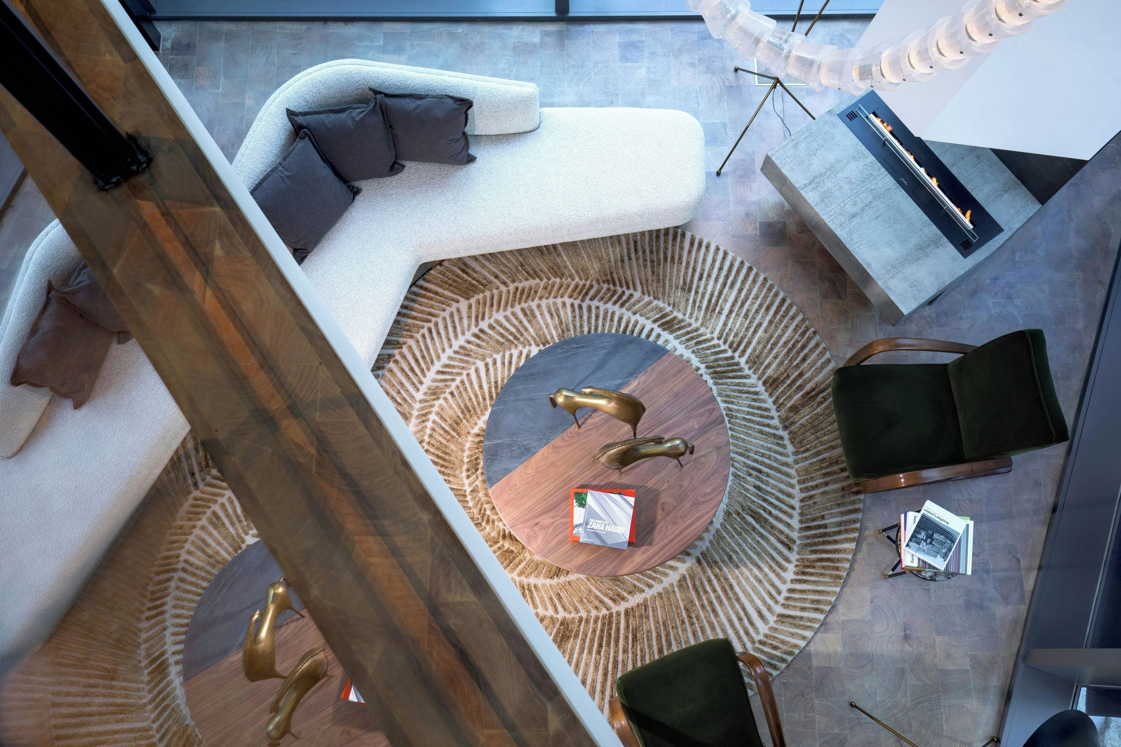 A modern living area with a circular rug, a sofa, a coffee table, and decorative items.