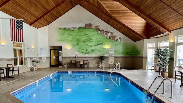 Ein Hallenbad mit Holzbalkendecke, einem Landschaftsgemälde und einer Flagge.