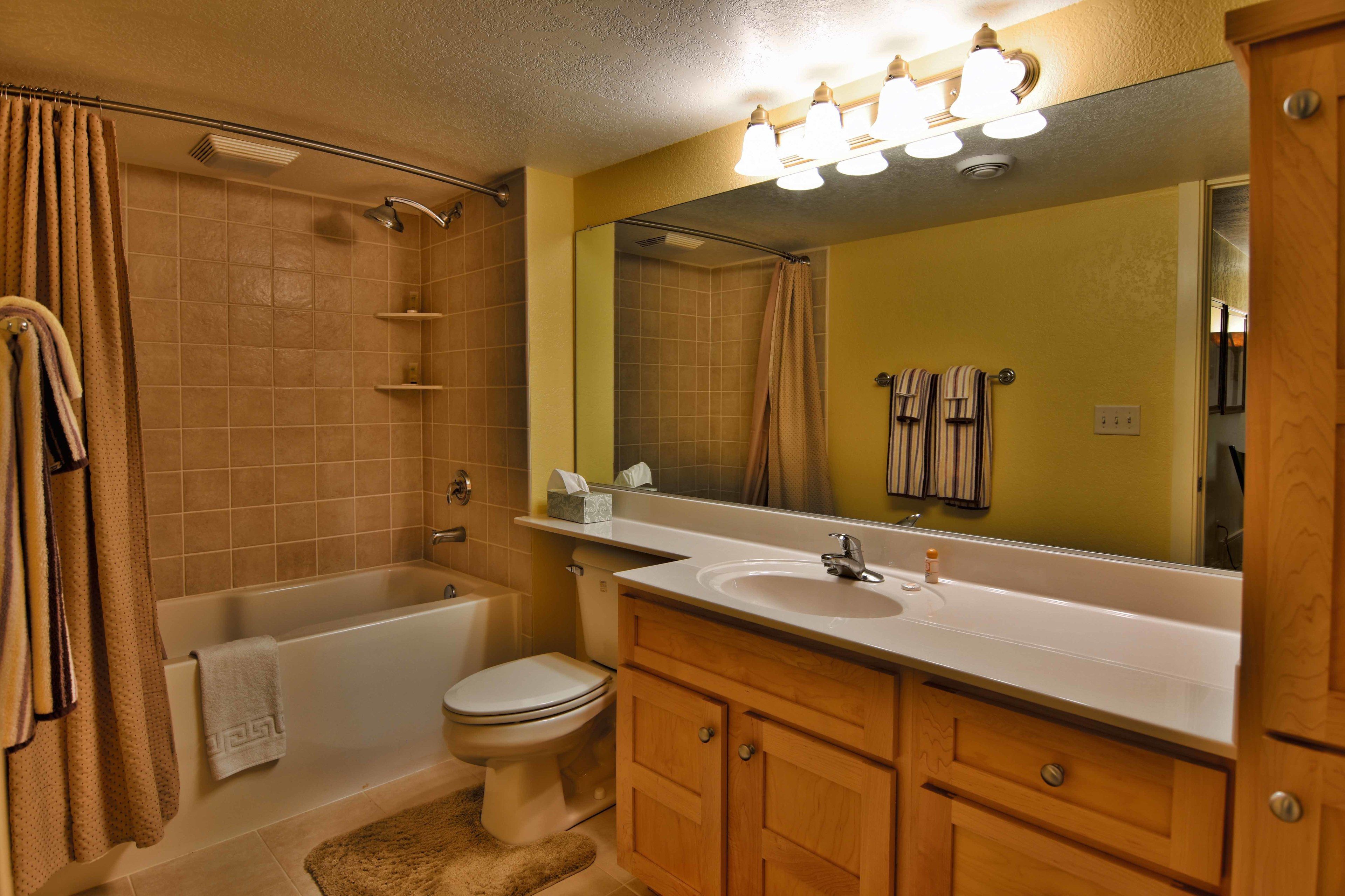 A bathroom with a bathtub, toilet, sink, and vanity.