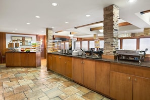 Una cocina amplia con un muro decorativo de piedra, una barra tipo buffet y una estación de parrilla.