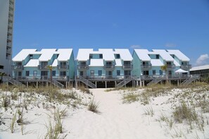 A beachfront hotel with multiple balconies and a sandy beach in front. - Ocean Reef 702 3 Bedroom Townhouse by RedAwning (Gulf Shores)