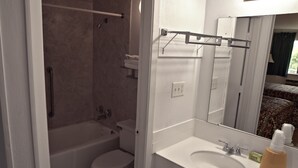A bathroom with a bathtub, toilet, sink, and a mirror.