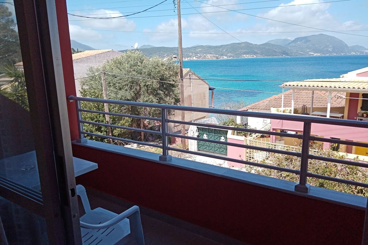 A balcony with a view of the sea and mountains.