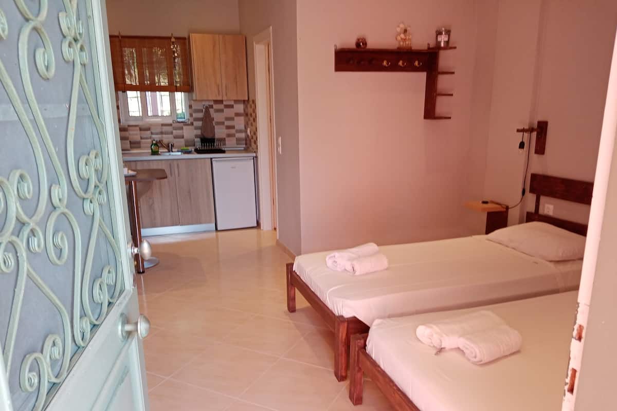 A bedroom with two beds, a small bedside table, and a nightstand.