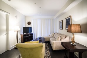 Apartamento luxo, 1 cama Queen, acessível | Área de estar | TV de tela plana